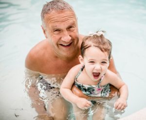 A man and a little girl in the water.